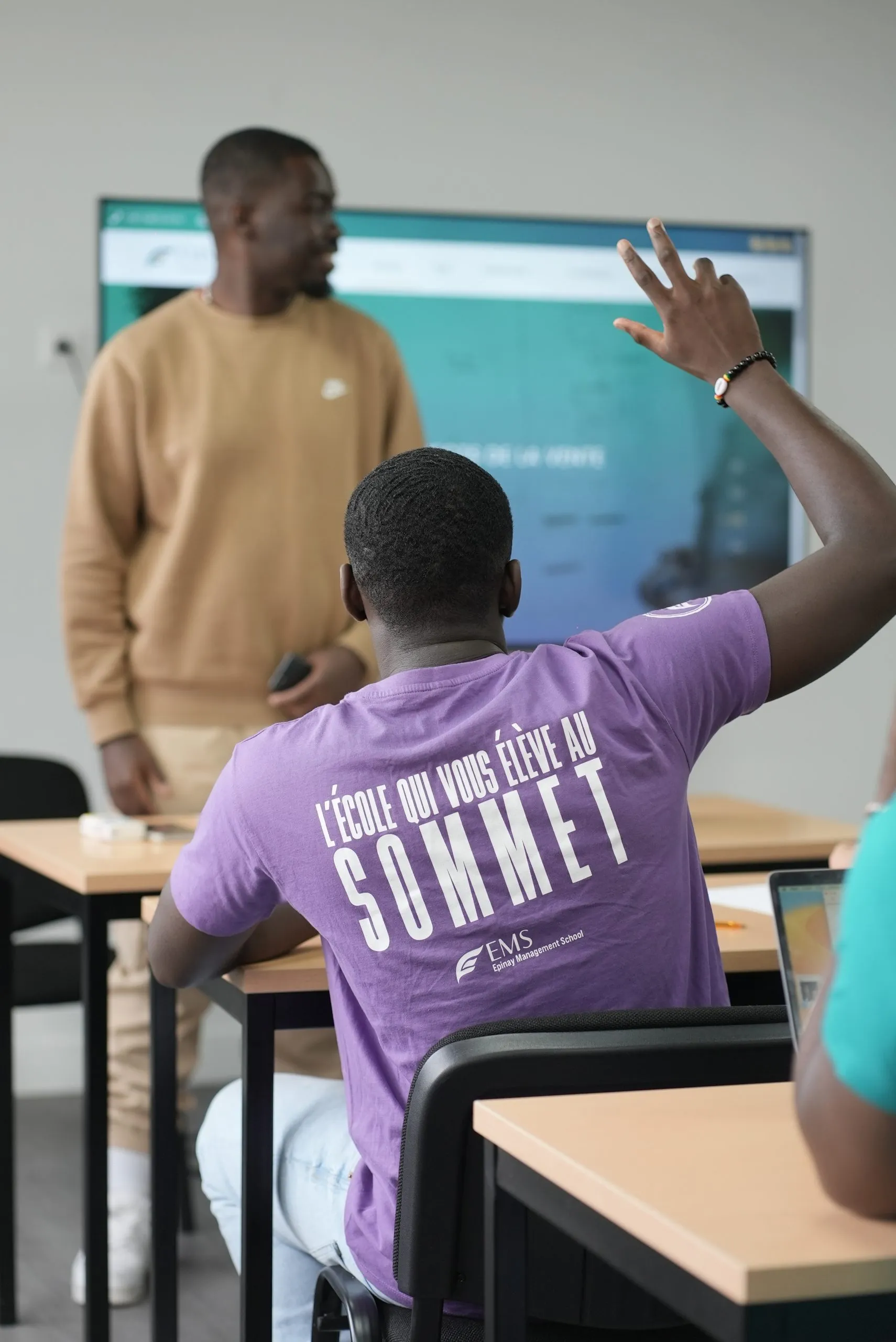 Étudiants en cours à EMS, en t-shirt « L’école qui vous élève au sommet »